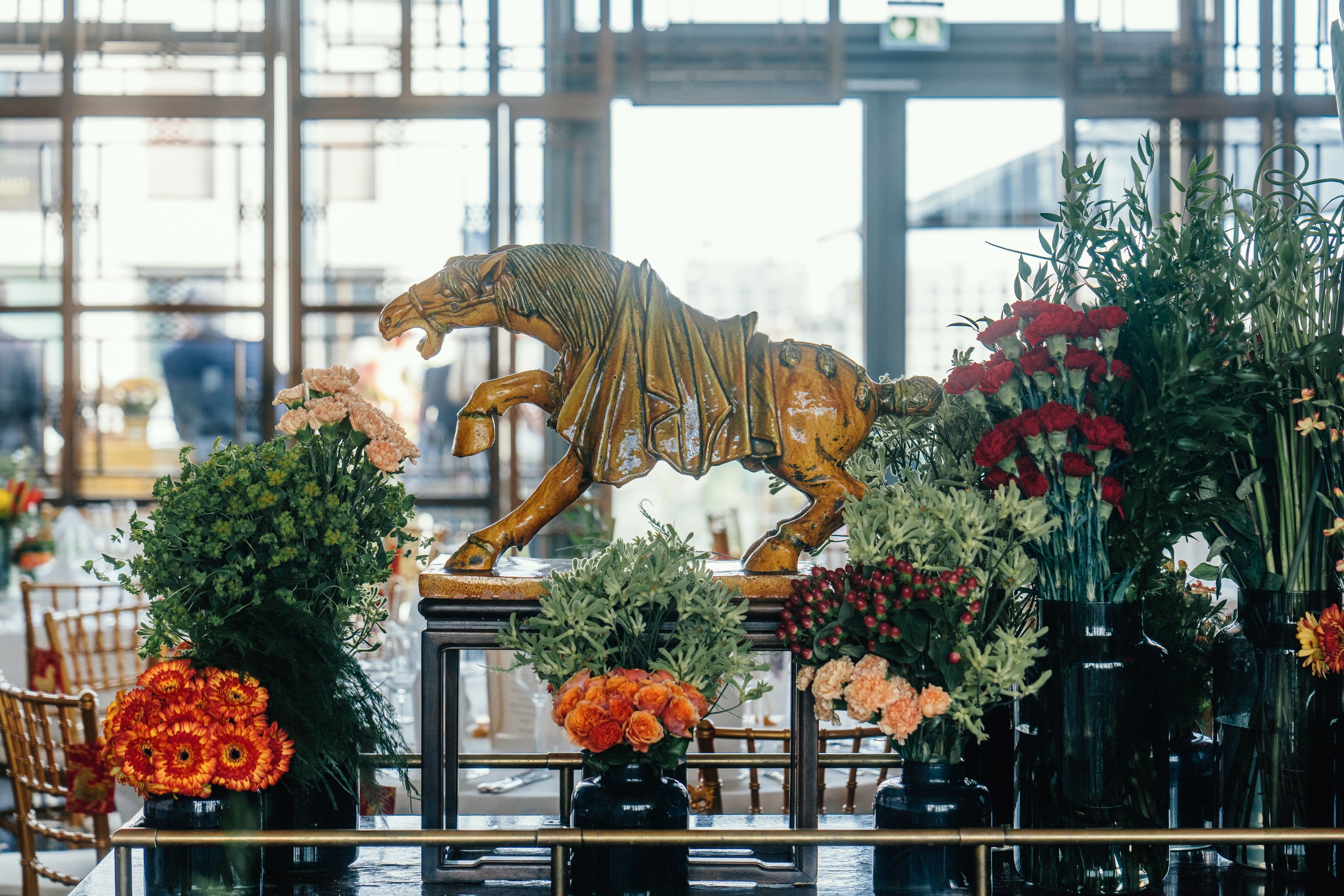 Eine vergoldete Tigerskulptur als Tafelaufsatz zwischen Blumenarrangements